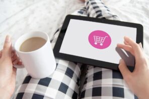 Eine Frau mit einer Kaffeetasse und Tablet gemütlich online shoppen